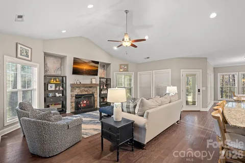 a living room with furniture a fireplace and a flat screen tv