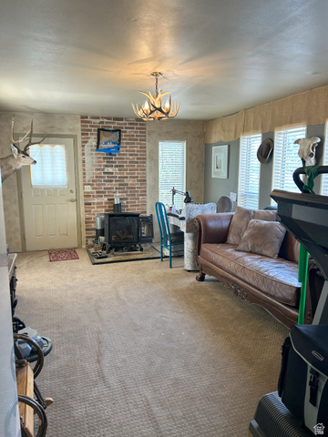 40 South State Street Scipio, UT 84656 - Photo 20 of 39 Living area with a wood stove, carpet, and a chandelier