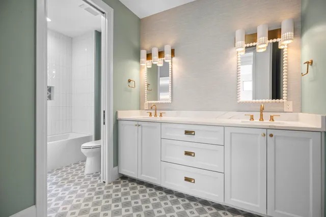 a bathroom with a sink a toilet and a large mirror