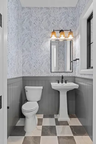 a bathroom with a sink toilet and mirror