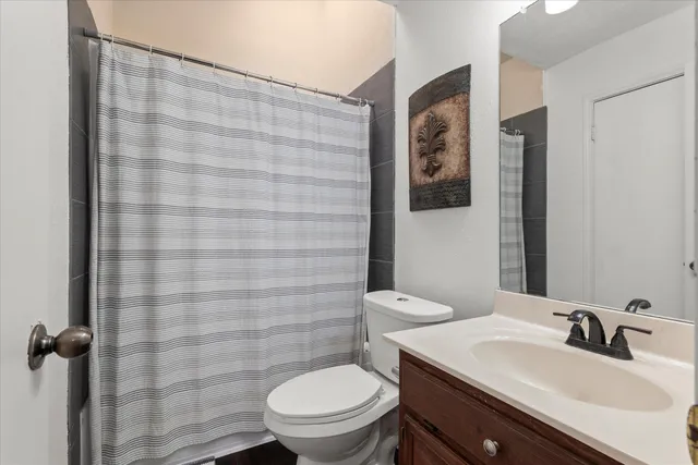 a bathroom with a sink a toilet and shower curtain