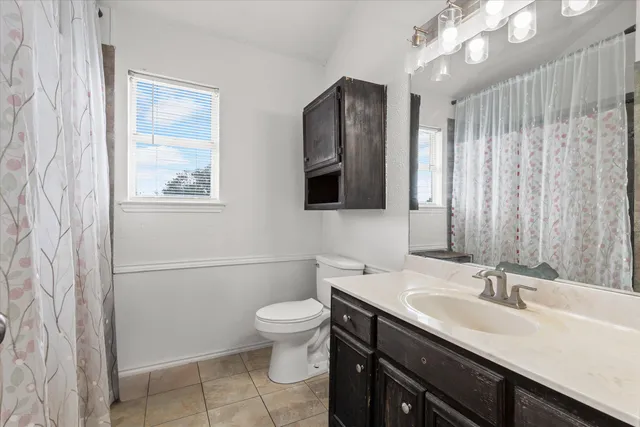 a bathroom with a double vanity sink a toilet and mirror