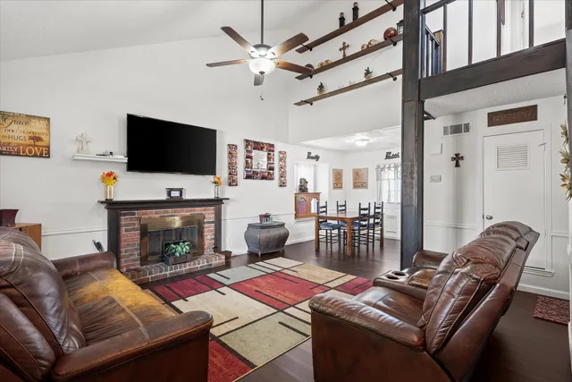 a living room with furniture a flat screen tv and a fireplace