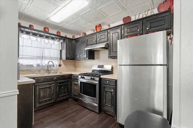 a kitchen with stainless steel appliances granite countertop a stove a refrigerator and a sink