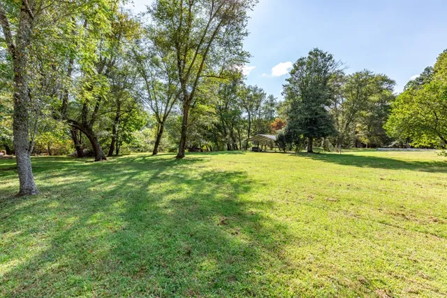 a swimming pool with trees in the background
