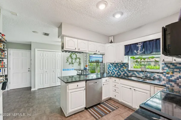 a kitchen with stainless steel appliances a stove a sink and a microwave