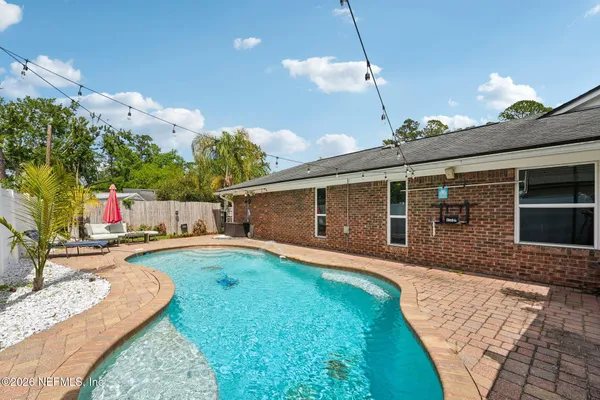 an aerial view of a house with swimming pool and a yard