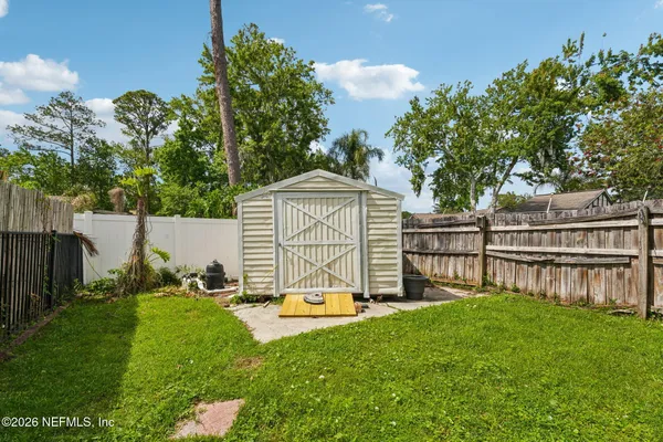 an aerial view of residential houses with outdoor space and trees