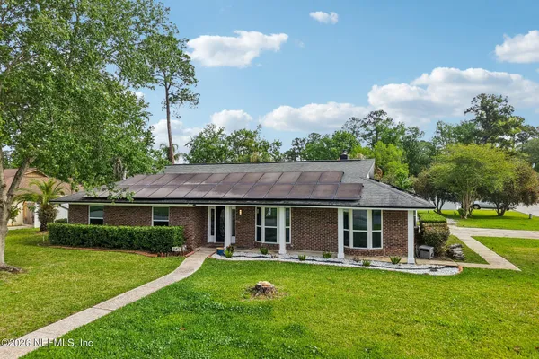 an aerial view of residential houses with outdoor space and trees