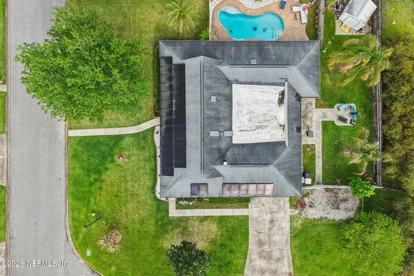 a front view of a house with a garden and trees