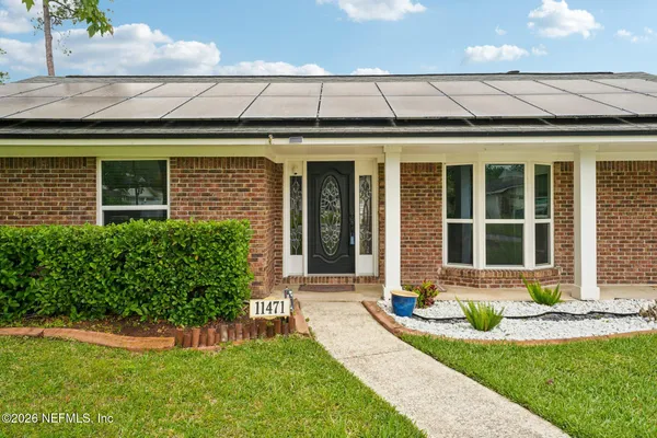 a view of a hallway with wooden floor and furniture