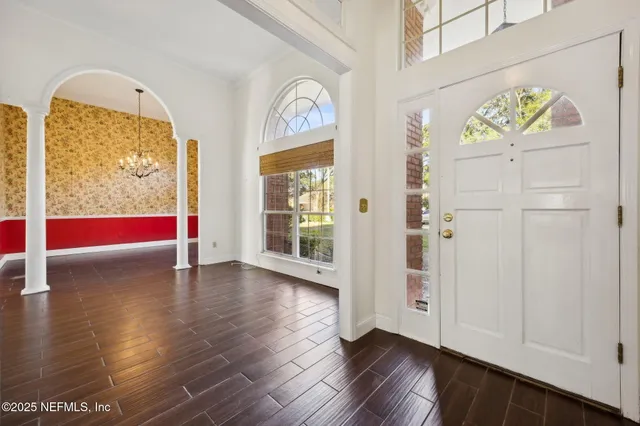 a view of empty room with wooden floor and large windows