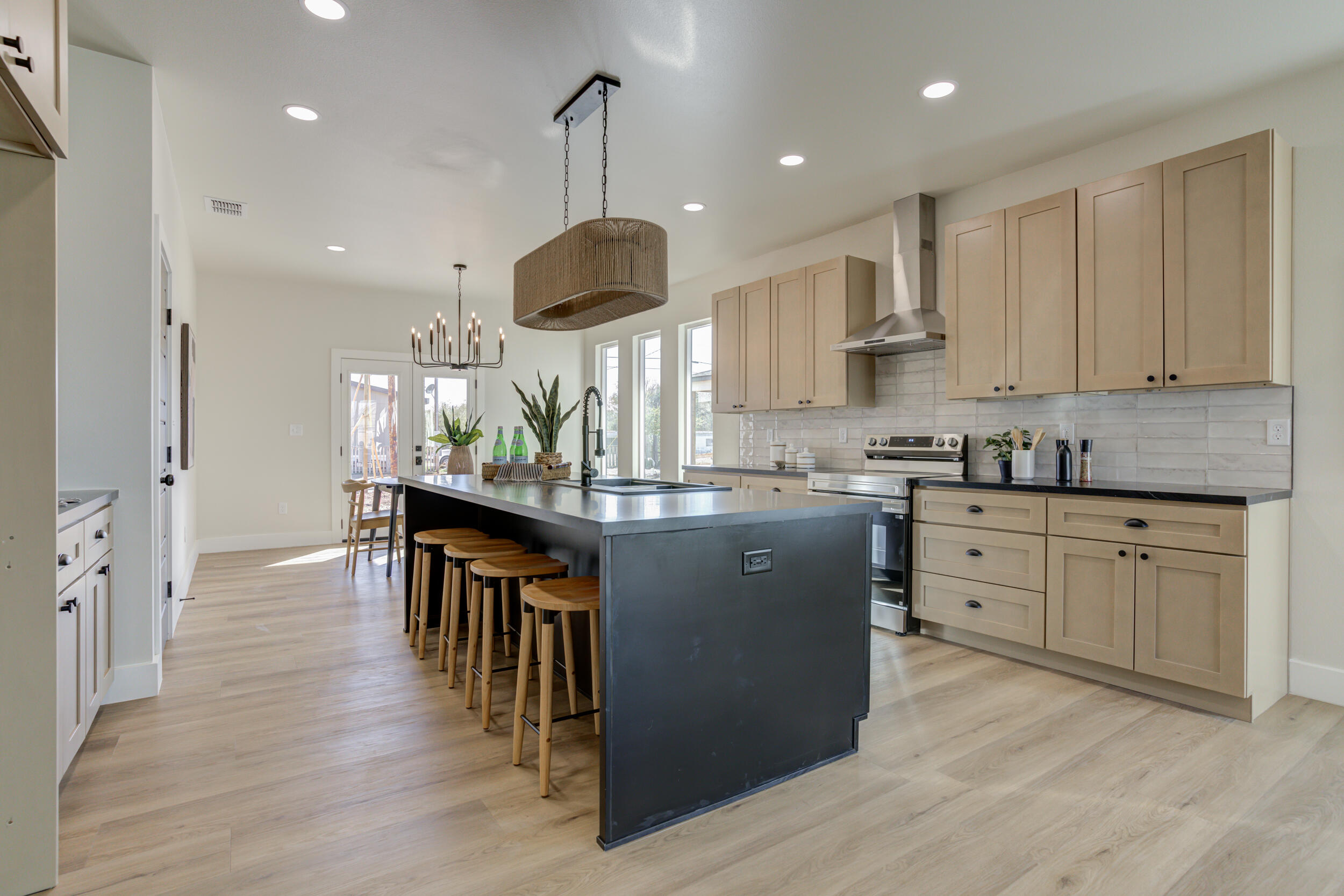 305 Southwest Ave L Seminole, TX 79360 - Photo 17 of 52 a kitchen with stainless steel appliances kitchen island granite countertop a stove a sink a refrigerator and a wooden cabinets