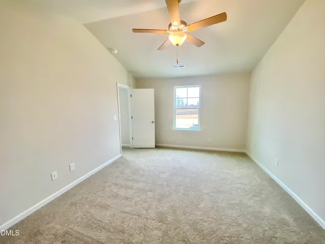 an empty room with a window and a ceiling fan