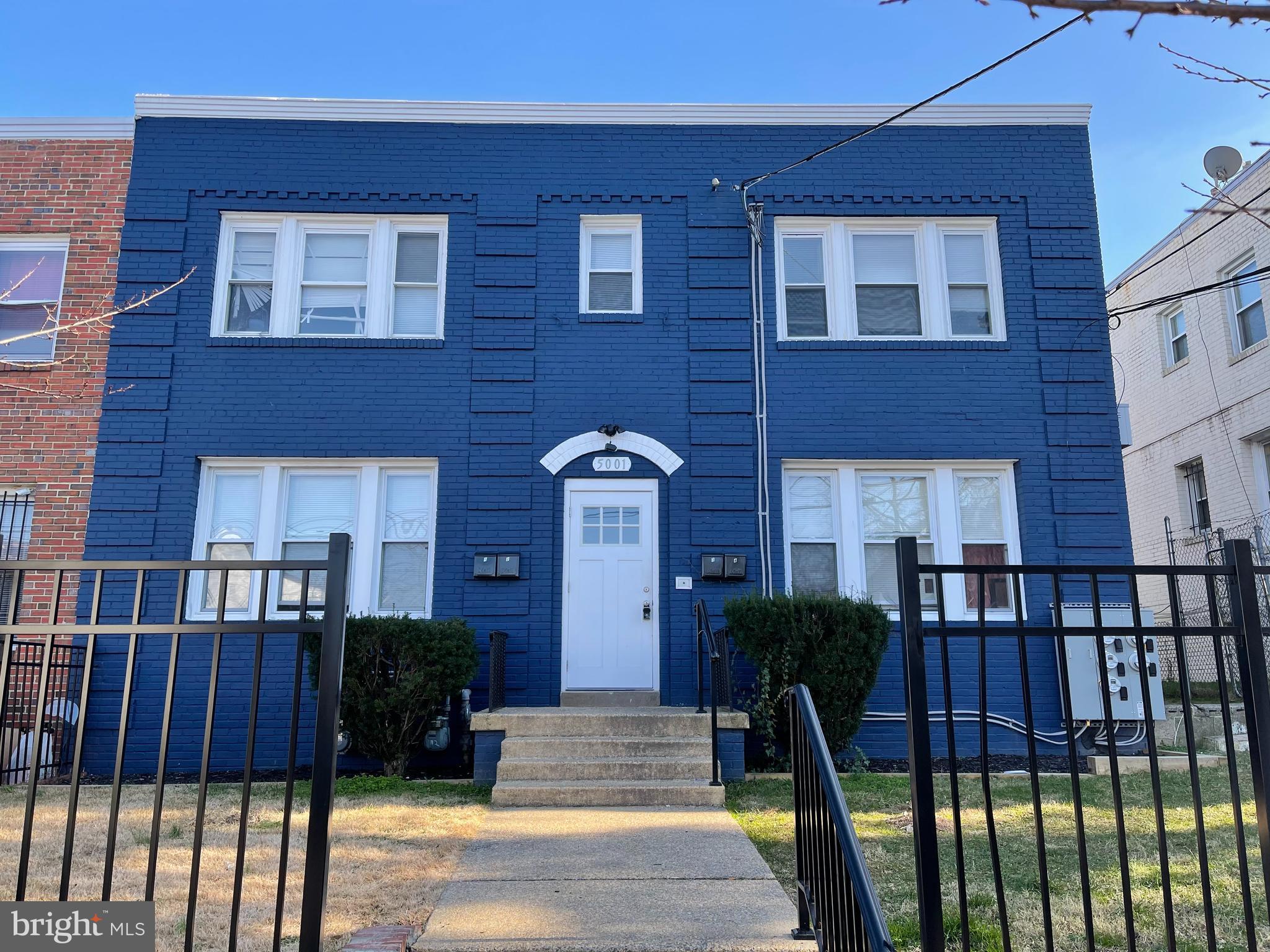 a view of a brick house with large windows and a table