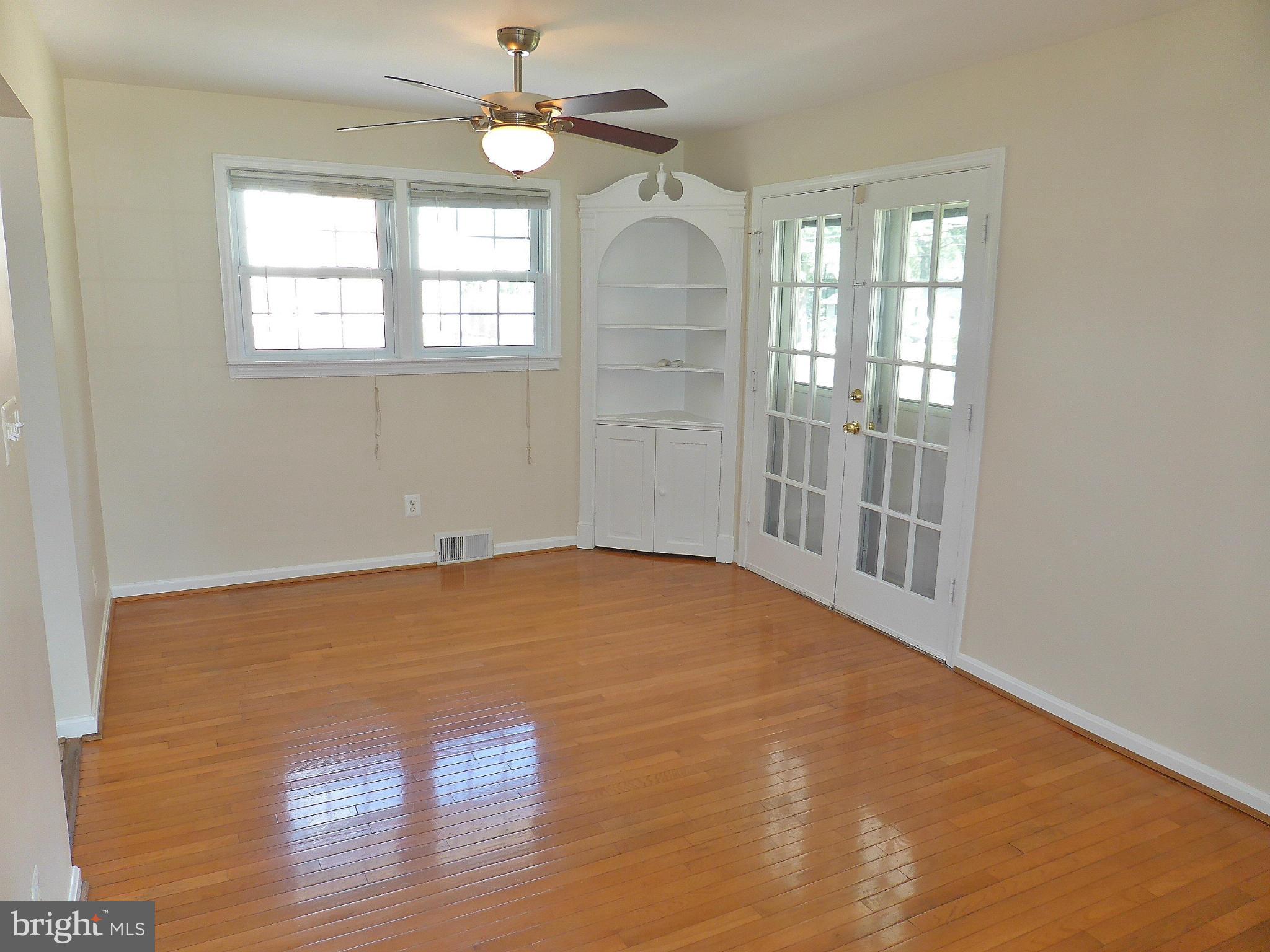 5208 Heming Avenue Springfield, VA 22151 - Photo 3 of 20 an empty room with wooden floor fan and windows