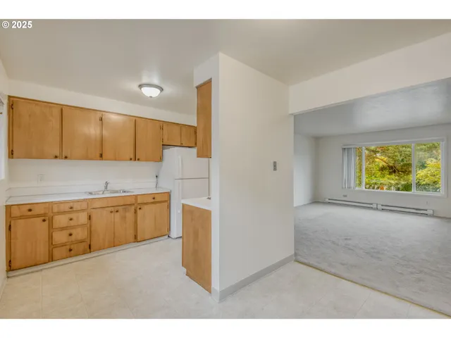 a kitchen with granite countertop white cabinets and window