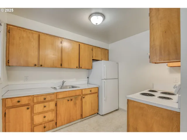 a kitchen with cabinets a refrigerator and a stove