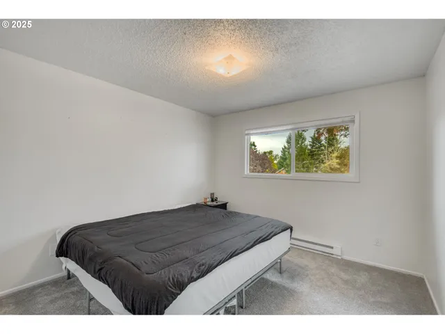 a bedroom with a bed and a painting on the wall