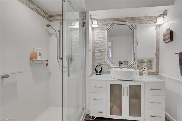 a bathroom with a double vanity sink mirror and shower