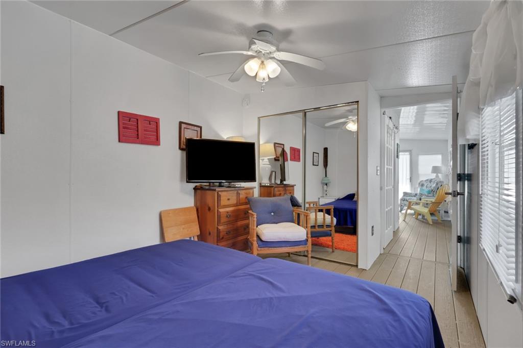 143 Moorhead Manor, Unit 143 Naples, FL 34112 - Photo 17 of 35 Bedroom featuring hardwood / wood-style flooring, a ceiling fan, and a closet