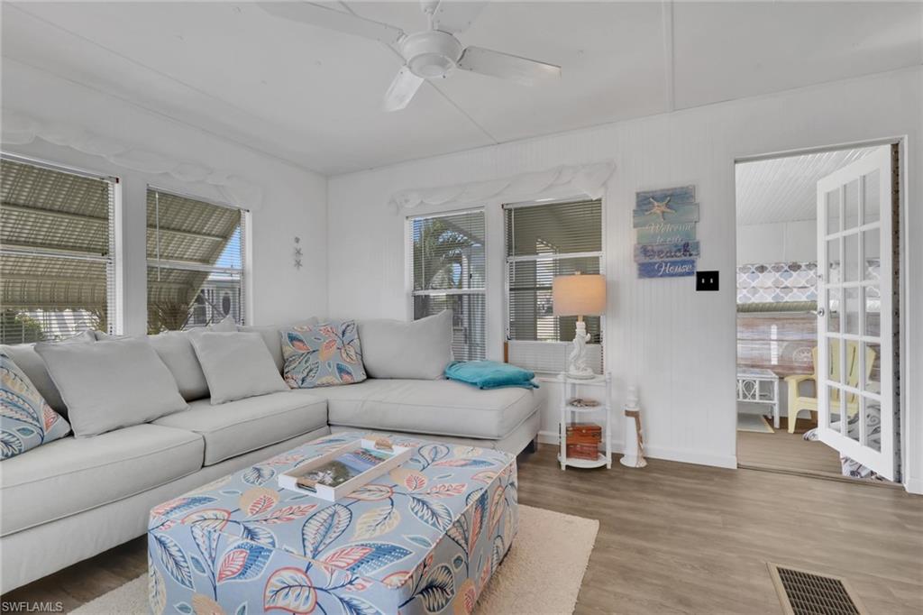 143 Moorhead Manor, Unit 143 Naples, FL 34112 - Photo 2 of 35 Living room featuring a ceiling fan and wood finished floors