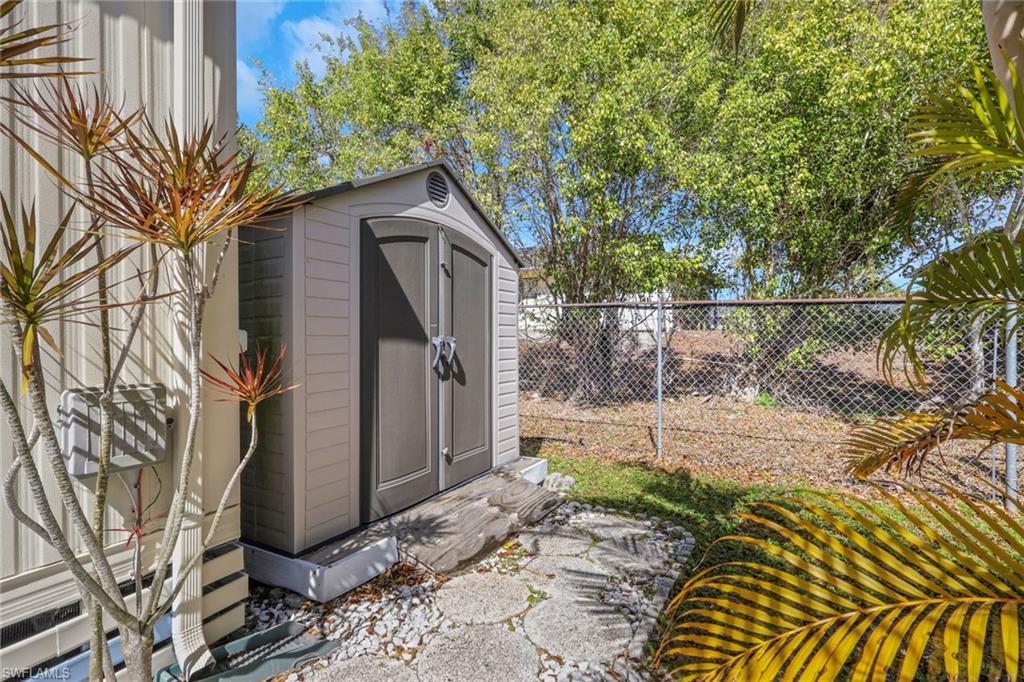 143 Moorhead Manor, Unit 143 Naples, FL 34112 - Photo 25 of 35 View of shed featuring a fenced backyard