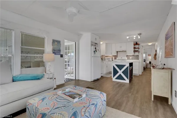 a living room with stainless steel appliances kitchen island granite countertop furniture and wooden floor