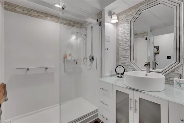 a bathroom with a shower sink and mirror