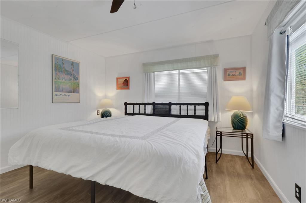 143 Moorhead Manor, Unit 143 Naples, FL 34112 - Photo 33 of 35 Bedroom featuring wood finished floors and ceiling fan