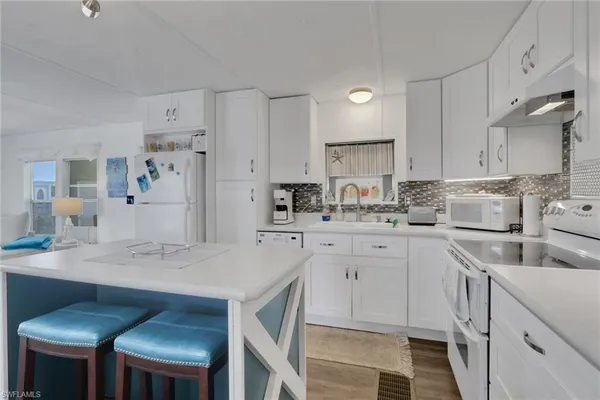 a kitchen with a sink cabinets and wooden floor