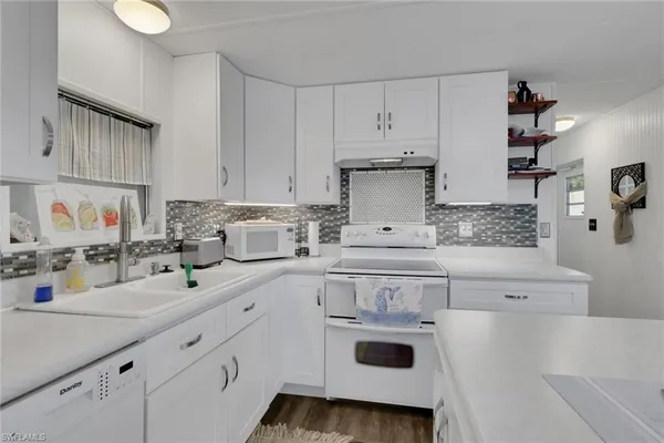 a kitchen with a sink a stove and cabinets
