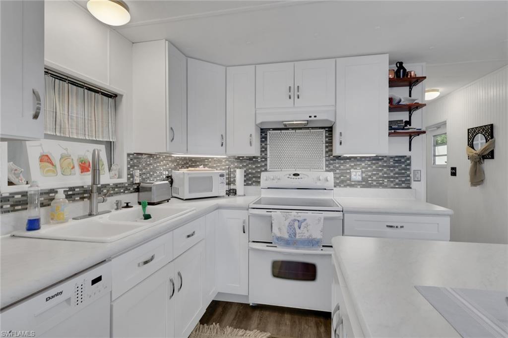 143 Moorhead Manor, Unit 143 Naples, FL 34112 - Photo 7 of 35 Kitchen featuring white appliances, white cabinets, light countertops, and open shelves