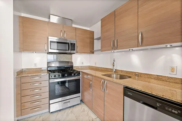 a kitchen with stainless steel appliances white cabinets and a stove top oven