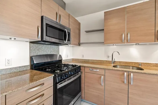 a kitchen with stainless steel appliances granite countertop a sink stove top oven and microwave