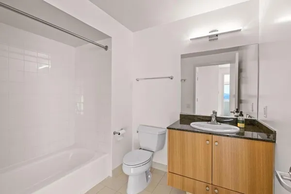 a bathroom with a granite countertop sink mirror toilet and bathtub
