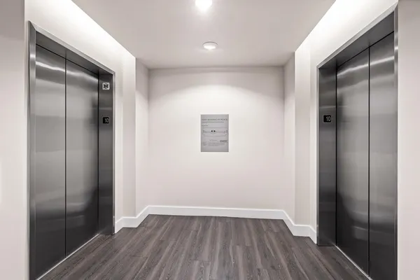 a view of an empty room with wooden floor and closet