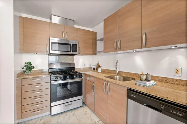 a kitchen with stainless steel appliances granite countertop a sink stove and microwave