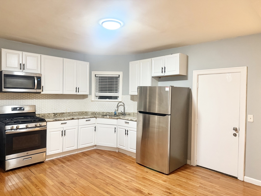 a kitchen with a refrigerator and a stove top oven