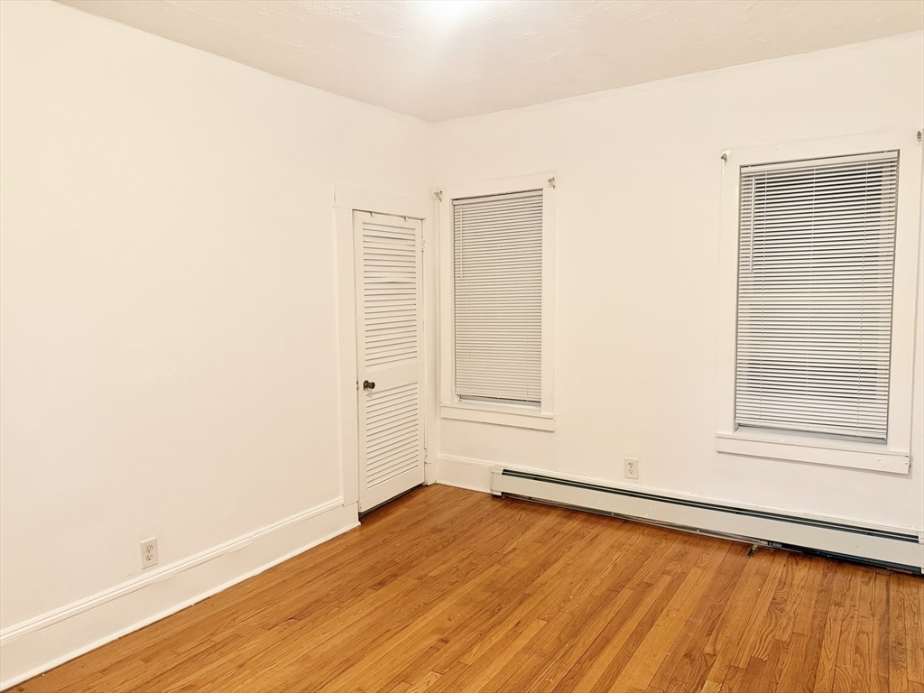 14 Addison Avenue, Unit 2 Brockton, MA 02302 - Photo 3 of 7 an empty room with wooden floor and windows