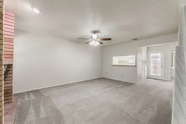 an empty room with windows and ceiling fan