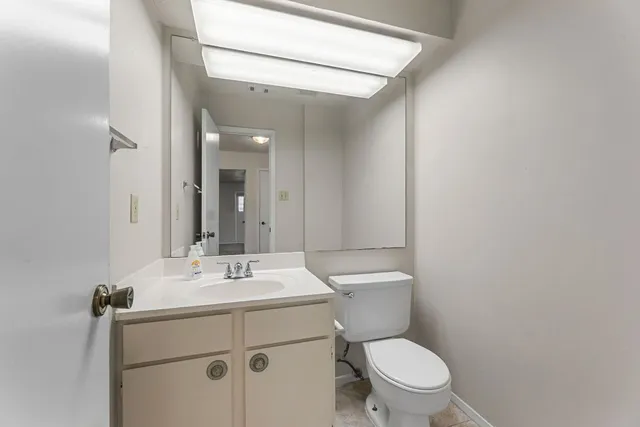 a bathroom with a toilet sink and mirror