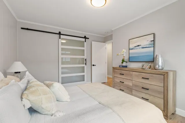 a bedroom with a bed and a mirror on dresser