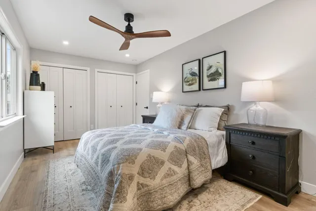 a spacious bedroom with a bed and a ceiling fan
