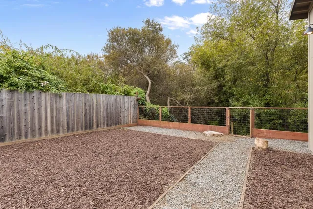 a view of backyard with wooden fence