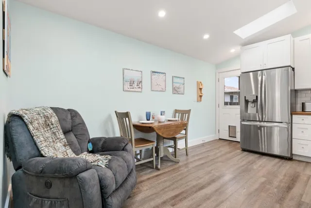 a living room with furniture and a refrigerator