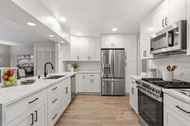 a kitchen with stainless steel appliances granite countertop a refrigerator sink and stove