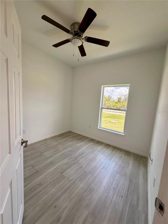 14142 Appleton Boulevard Port Charlotte, FL 33981 - Photo 16 of 26 a view of an empty room with wooden floor and a window