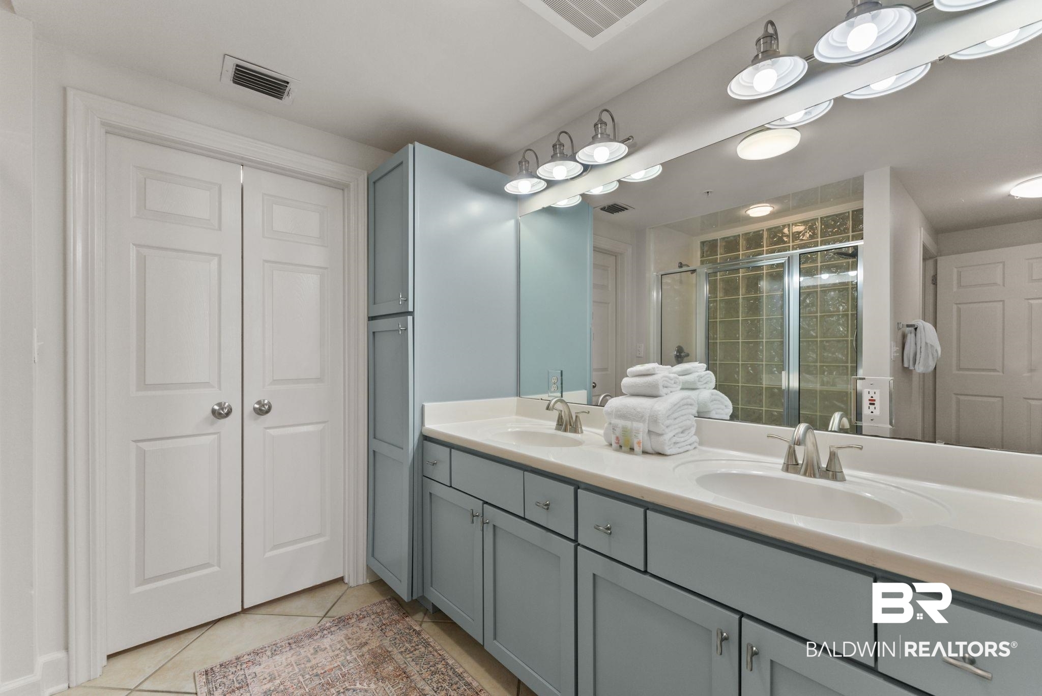 27580 Canal Road, Unit 1233 Orange Beach, AL 36561 - Photo 21 of 79 Bathroom featuring double vanity, light tile patterned floors, and a stall shower