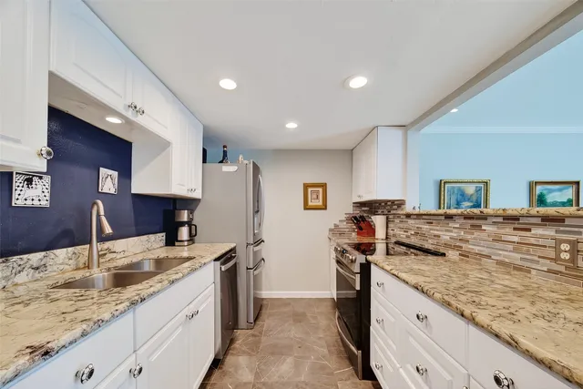 a kitchen with granite countertop a sink and a stove